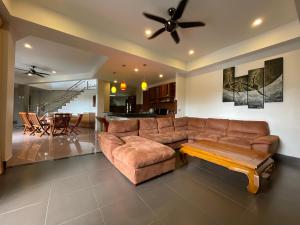 a living room with a brown couch and a table at Вилла в сердце Пхукета in Ban Lum Fuang