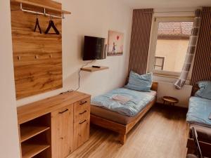 a small room with a bed and a desk at Er-is Zimmervermietung in Würzburg