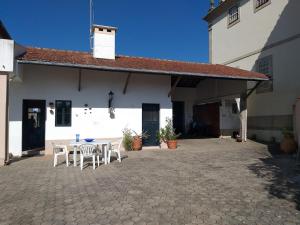 a patio with a table and chairs in front of a building at Casa da Carlota in São Vicente de Pereira Jusã