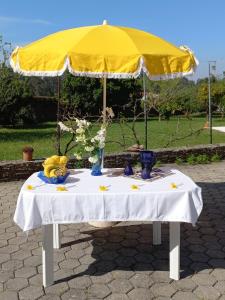 a table with a yellow umbrella on top of it at Casa da Carlota in São Vicente de Pereira Jusã