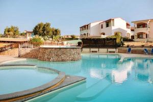 a swimming pool with blue water in front of a building at ISA-Hotel with swimming pool just 300 mt from the Baia delle Mimose-beach in Badesi