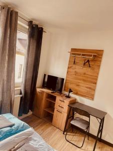 a bedroom with a desk with a computer and a bed at Er-is Zimmervermietung in Würzburg +26 photos