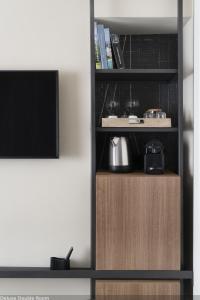 une étagère avec une télévision dans la chambre dans l'établissement Della Spiga Suites by Brera Apartments, à Milan