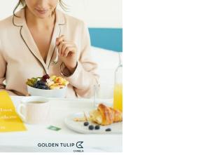 a woman sitting at a table with a plate of food at Golden Tulip Canela in Canela +4 photos