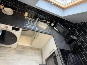 海斯Letzi Premium Cozy Retreat Private En-Suite Rooms, Heathrow Airport的配有水槽和微波炉的厨房