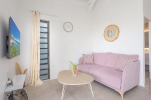 un soggiorno con un divano viola e un tavolo di Bungalow Visão a Sainte-Anne