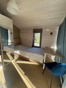 a small room with a bed and a chair at La Dacha Montanya in Seva +61 photos