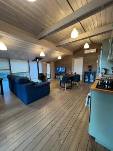 a living room with a blue couch and a kitchen at La Dacha Montanya in Seva
