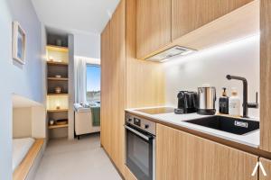 a kitchen with a sink and a stove at Modern and Cozy Studio Retreat near the City in Luxembourg