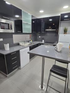a kitchen with black cabinets and a table and chairs at AL Manas Pereira in Castro Marim