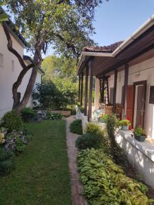 a walkway next to a house with a tree at Klára apartman in Sárospatak