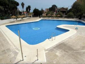 a large swimming pool with blue water at Pura Vida King-Size Bed Sea and Mountain view Apartment in Benalmádena