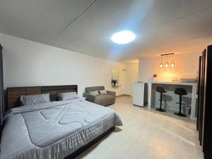 a bedroom with a large bed and a desk at T12 Popular Condo By hunnity 2 in Ban Bang Phang