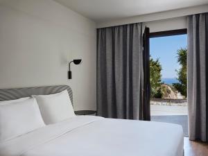 Una cama o camas en una habitación de Doryssa Lithos Hotel