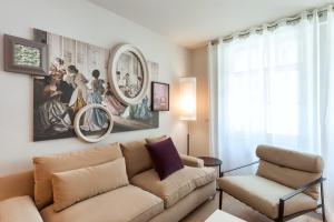 uma sala de estar com um sofá e uma cadeira em Guillaume Suites no Luxemburgo
