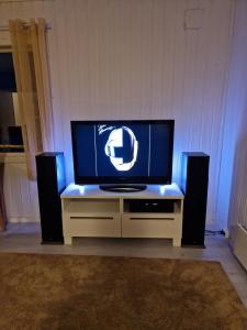 TV de pantalla plana en un centro de entretenimiento con altavoces en Mellomgaard - southern-Kvaløya, en Tromsø