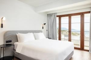 Una cama o camas en una habitación de Doryssa Lithos Hotel