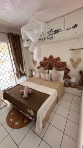 un dormitorio con una cama grande en una habitación en L'HIBISCUS rénové Sept 2025, en Saint-François