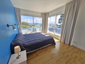 una camera da letto con un letto grande con una grande finestra di Le Trez', vue mer imprenable a Plougonvelin
