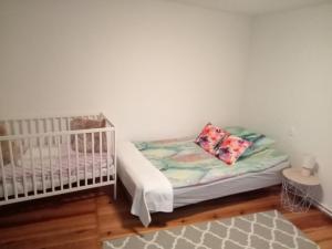 a baby room with a crib and a bed with pillows at Apartament Brójce Lubuskie in Brójce