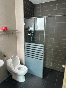 a bathroom with a toilet and a shower and a sink at Lp Homestay Miri in Miri +1 photo