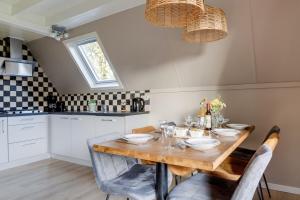 a kitchen with a wooden table with chairs and a dining room at Houtduif I Huisje met Omliggende Tuin in Zwiggelte