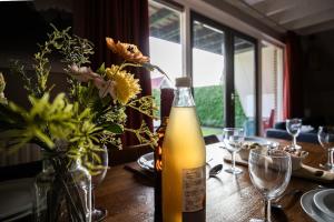 a bottle of wine sitting on a table with flowers at Houtduif I Huisje met Omliggende Tuin in Zwiggelte