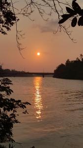 a sunset over a body of water with the sun at Rustic Campsite Kalutara South in Kalutara