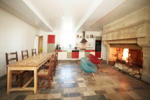 a kitchen with a wooden table and a fireplace at Ferme de Franqueville in Sainte-Marie-du-Mont