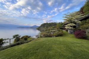 a house on the shore of a body of water at Classic, elegant private villa opposite lake in Ispra