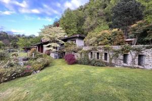 an old stone house with a yard at Classic, elegant private villa opposite lake in Ispra
