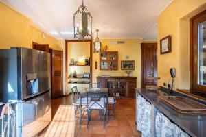 Una cocina con refrigerador de acero inoxidable y una mesa. en Relais Dolce Lago, en Lesa