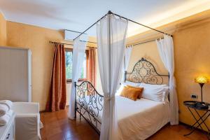 Un dormitorio con una cama con dosel y una ventana. en Relais Dolce Lago, en Lesa