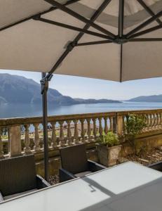 a table and chairs on a balcony with a view of the water at Villa Bruna in Ghiffa