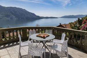 a table and chairs on a balcony with a view of a lake at Villa Bruna in Ghiffa
