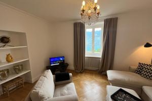 a living room with a white couch and a chandelier at Villa Bruna in Ghiffa