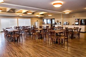 布蘭登的住宿－Lakeview Inns & Suites - Brandon，用餐室配有木桌和椅子