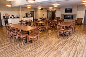 a dining room with wooden tables and chairs at Lakeview Inns & Suites - Brandon in Brandon