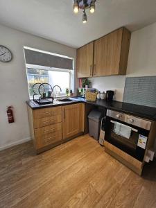 a kitchen with a sink and a stove top oven at 2 Bed Coastal Bungalow - Millendreath, Looe in Looe +16 photos