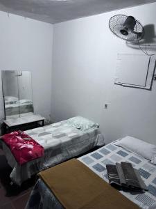 a room with two beds and a fan on the wall at Rancho FILADÉLFIA in Guapimirim