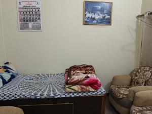 Habitación con 1 cama, 1 silla y 1 foto en Sangam bhawan, en Prayagraj