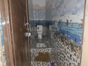 baño con aseo y pared de mosaico en Sangam bhawan, en Prayagraj