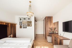 a bedroom with two beds and a flat screen tv at Romantik Hotel Jagdhof in Caldaro