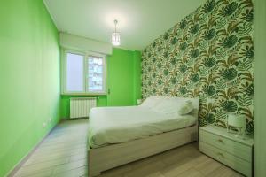 a bedroom with a bed with a green wall at Michele Flat - Parcheggio - 10 min da Milano Centro in Milan