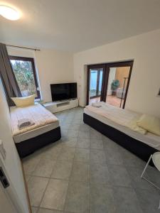 a bedroom with two beds and a television in it at Unterkünfte nahe Einfelder See, in Neumünster
