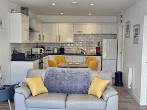 a living room with a couch and a kitchen at Sea view Villa Millendreath Looe in Looe +13 photos