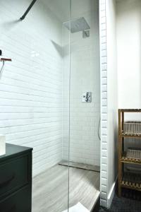 a glass shower in a bathroom with white walls at Le Square in Le Havre +26 photos