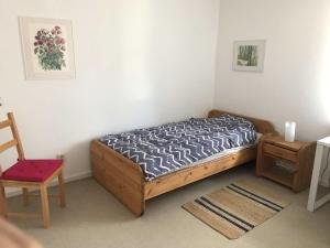 a small bedroom with a bed and a chair at Ferienhaus am Kanal in Rendsburg