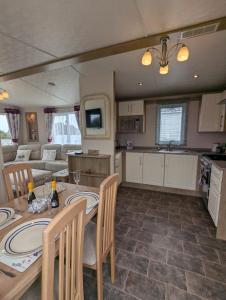 a kitchen and living room with a table and chairs at BRIGHT and COMFORTABLE HOLIDAY HOME SWANAGE BAYVIEW HOLIDAY PARK in Swanage