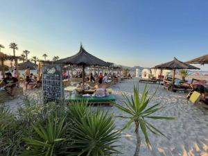 a group of people sitting on a beach with umbrellas at Kilians apartment 2 in Castellón de la Plana